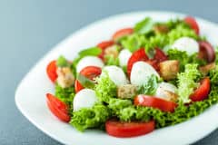 serving-fresh-salad-mozzarella-pearls-leafy-green-tomato-fried-golden-crunchy-croutons-close-up-low-angle-view-43418442